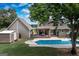 Backyard view featuring a pool, covered deck, shed, and mature trees at 411 Hampton Rd, Fayetteville, GA 30215