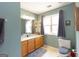 Well-lit bathroom with a vanity, large mirror, and a window covered with gray curtains at 411 Hampton Rd, Fayetteville, GA 30215