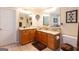 Bright bathroom featuring granite countertops, wood cabinets, dual sinks, and tile floors at 411 Hampton Rd, Fayetteville, GA 30215