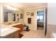 Bright bathroom featuring granite countertops, wood cabinets, dual sinks, and tile floors at 411 Hampton Rd, Fayetteville, GA 30215