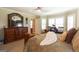 This spacious bedroom featuring elegant wooden furniture, neutral walls, and a desk with a large window at 411 Hampton Rd, Fayetteville, GA 30215