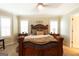 This spacious bedroom featuring elegant wooden furniture, neutral walls, and a ceiling fan at 411 Hampton Rd, Fayetteville, GA 30215