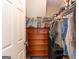 Organized walk-in closet featuring a wooden dresser and clothing rack with hats, helmets, and luggage on the top shelf at 411 Hampton Rd, Fayetteville, GA 30215