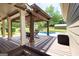 Covered deck with wooden pergola, dining table and chairs overlooking the pool and backyard at 411 Hampton Rd, Fayetteville, GA 30215
