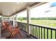 Inviting porch view with rocking chairs overlooking lush green pastures, perfect for relaxing outdoors at 411 Hampton Rd, Fayetteville, GA 30215