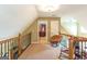 Upstairs hallway landing with a cushioned chair and doorway views into adjacent rooms at 411 Hampton Rd, Fayetteville, GA 30215