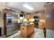 Well-lit kitchen features stainless steel appliances, wood cabinets, central island and tile backsplash at 411 Hampton Rd, Fayetteville, GA 30215