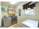 Laundry room featuring modern washer and dryer with storage shelves and a window for natural light at 411 Hampton Rd, Fayetteville, GA 30215
