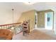 Bright carpeted loft area with decorative rocking chair and view of multiple bedrooms at 411 Hampton Rd, Fayetteville, GA 30215