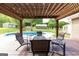 Inviting patio featuring a pergola, comfortable seating, and a view of the in-ground pool, offering an ideal outdoor living space at 411 Hampton Rd, Fayetteville, GA 30215