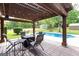 Inviting patio with pergola, comfortable seating, and an in-ground pool in a private backyard setting, perfect for outdoor entertaining at 411 Hampton Rd, Fayetteville, GA 30215