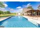 In-ground pool with a tanning ledge, a wooden pergola, a quaint shed and a well-manicured lawn providing a private outdoor oasis at 411 Hampton Rd, Fayetteville, GA 30215