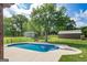 Inviting in-ground pool with a diving board, surrounded by a well-maintained lawn and mature trees, offering a serene backyard retreat at 411 Hampton Rd, Fayetteville, GA 30215