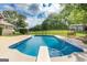 Relaxing in-ground pool with diving board, surrounded by a manicured lawn and mature trees, ideal for leisure and outdoor enjoyment at 411 Hampton Rd, Fayetteville, GA 30215
