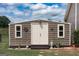 Outdoor shed with double doors, two windows, decorative items, and a small statue at 411 Hampton Rd, Fayetteville, GA 30215