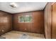 Bedroom with brown paneling and a window overlooking the greenery outside at 6109 Oakwood Sw Cir, Covington, GA 30014