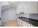 Functional laundry room with white cabinets, dark countertop, and a stainless steel sink at 1212 Lee Whatley Dr, Lithonia, GA 30058
