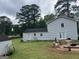 Spacious backyard with blue sided home, green grass and a fire pit at 1125 Babbs Mill Rd, Hampton, GA 30228