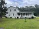 Spacious backyard featuring a lush green lawn and a charming two-story home with a covered porch at 1125 Babbs Mill Rd, Hampton, GA 30228