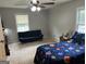 Neutral bedroom featuring a space-themed bedspread, ceiling fan, and sitting area at 1125 Babbs Mill Rd, Hampton, GA 30228