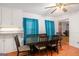 A dining area featuring a dark table, wooden chairs, blue curtains, and hardwood floors at 1125 Babbs Mill Rd, Hampton, GA 30228