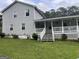 Cozy home featuring a charming porch, complemented by green lawn and mature trees at 1125 Babbs Mill Rd, Hampton, GA 30228