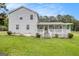 Charming gray home with a welcoming white porch, complemented by a lush green lawn and mature trees at 1125 Babbs Mill Rd, Hampton, GA 30228