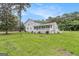 Scenic view of the home, highlighted by a large lawn, mature trees, and a charming covered porch at 1125 Babbs Mill Rd, Hampton, GA 30228