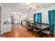 A kitchen with an adjacent dining area featuring a dark table, wooden chairs, and blue curtains at 1125 Babbs Mill Rd, Hampton, GA 30228