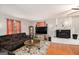 Cozy living room featuring a brick fireplace, plush sofa, hardwood floors, and plenty of natural light at 1125 Babbs Mill Rd, Hampton, GA 30228