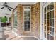 Covered porch with brick accents and large windows, providing ample natural light and views of the surrounding landscape at 2294 Hollonville Rd, Brooks, GA 30205