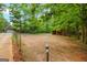 A view from the fenced in backyard to the main house with a large field and wooden shelter at 2294 Hollonville Rd, Brooks, GA 30205