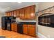 Well-lit kitchen with stainless steel appliances, granite counters, and cherry cabinets adjacent to stone fireplace at 2294 Hollonville Rd, Brooks, GA 30205