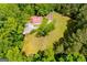 Aerial view showing the house nestled within a grove of trees and an expansive green space at 3258 South Mckoy Rd, Villa Rica, GA 30180