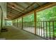 Spacious back porch featuring a wooden railing, concrete floor, and wooden ceiling beams at 3258 South Mckoy Rd, Villa Rica, GA 30180