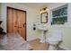 Bathroom showcasing pedestal sink, sliding barn door, decorative window, and light fixture at 3258 South Mckoy Rd, Villa Rica, GA 30180