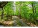 Rustic driveway with wooden and metal gates surrounded by lush trees at 3258 South Mckoy Rd, Villa Rica, GA 30180