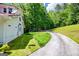 Two-story home with red roof and lush landscaping, nestled among mature trees and a curved driveway at 3258 South Mckoy Rd, Villa Rica, GA 30180