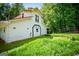 Lush green lawn surrounds a two-story house with a red roof, nestled among mature trees at 3258 South Mckoy Rd, Villa Rica, GA 30180
