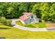 Charming two-story home with a red roof, set amidst a lush green lawn and surrounding trees at 3258 South Mckoy Rd, Villa Rica, GA 30180