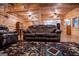 Comfortable living room featuring wood walls and floors, a large sofa, and a decorative rug at 3258 South Mckoy Rd, Villa Rica, GA 30180
