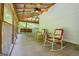 Cozy screened porch features a ceiling fan, rocking chairs, and a swing for relaxation at 3258 South Mckoy Rd, Villa Rica, GA 30180