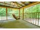 Inviting screened porch features a wooden swing, perfect for enjoying the serene wooded setting at 3258 South Mckoy Rd, Villa Rica, GA 30180