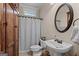 Charming bathroom featuring a pedestal sink, decorative mirror, and tiled floors at 124 Belford Way, Locust Grove, GA 30248
