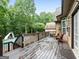 Relaxing wooden deck with outdoor seating overlooking the lush backyard and pool at 124 Belford Way, Locust Grove, GA 30248