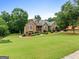 Beautiful brick home with lush green lawn and mature trees at 124 Belford Way, Locust Grove, GA 30248