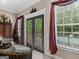 Bright living room features French doors to the outdoor pool area with a gorgeous burgundy-toned valance at 124 Belford Way, Locust Grove, GA 30248