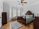 Bright main bedroom features a large bay window and beautiful, dark wood furniture at 124 Belford Way, Locust Grove, GA 30248