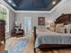 Main bedroom with gray walls, wood floors, and a view of the main bathroom at 124 Belford Way, Locust Grove, GA 30248