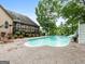 Beautiful pool area with a slide, patio, and well-maintained landscaping, perfect for outdoor enjoyment at 124 Belford Way, Locust Grove, GA 30248